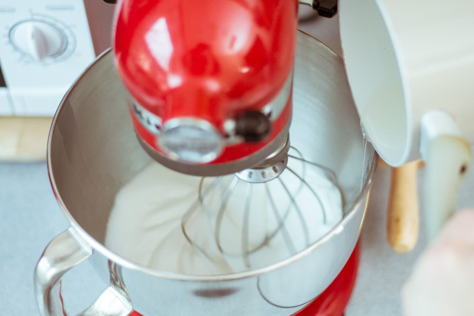 When the syrup reaches 116°C (240.8°F), slowly stream it down the side of a stand mixer bowl.